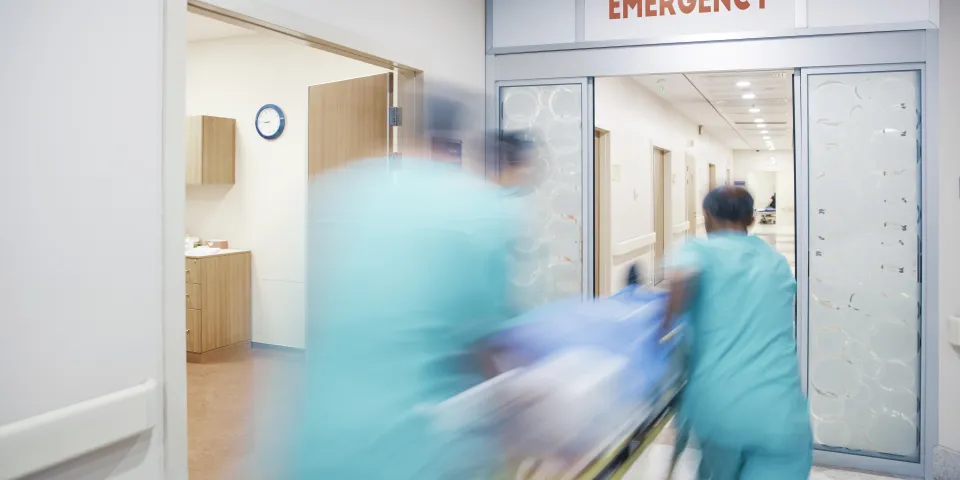 Nurses wheeling patient in emergency room