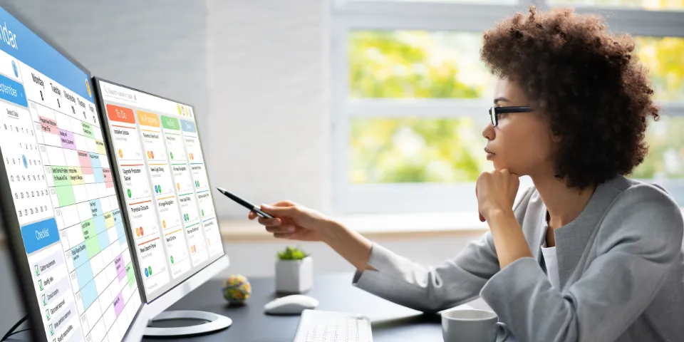 Project management team coordinating and update project planned schedule on computer