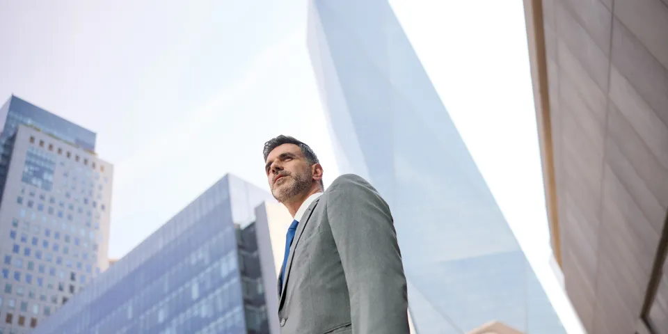 Man in a suit standing in the street.