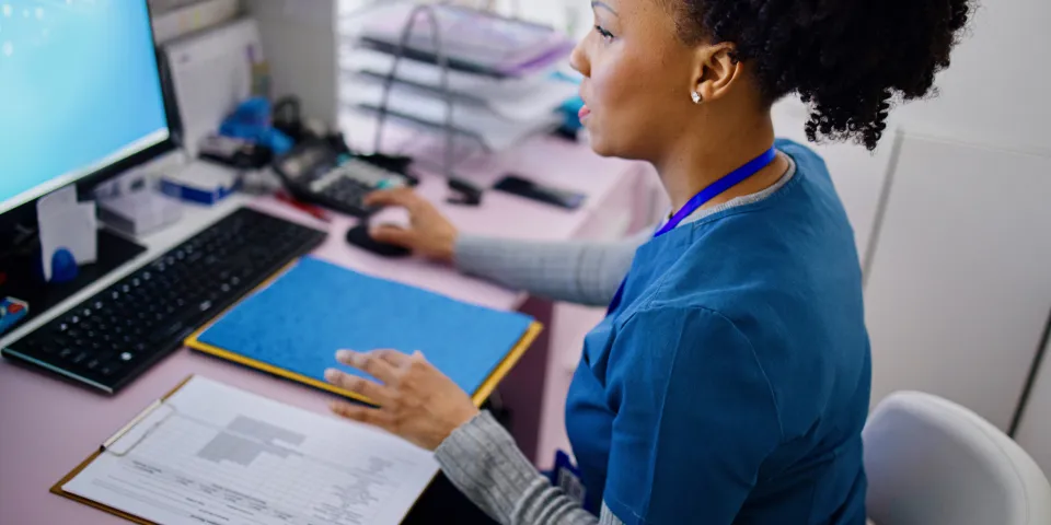 Black woman using computer to work as nurse in the private clinic.Black woman using computer to work as nurse in the private clinic.