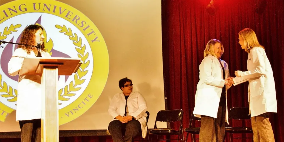 Herzing University Minneapolis white coat ceremony on stage