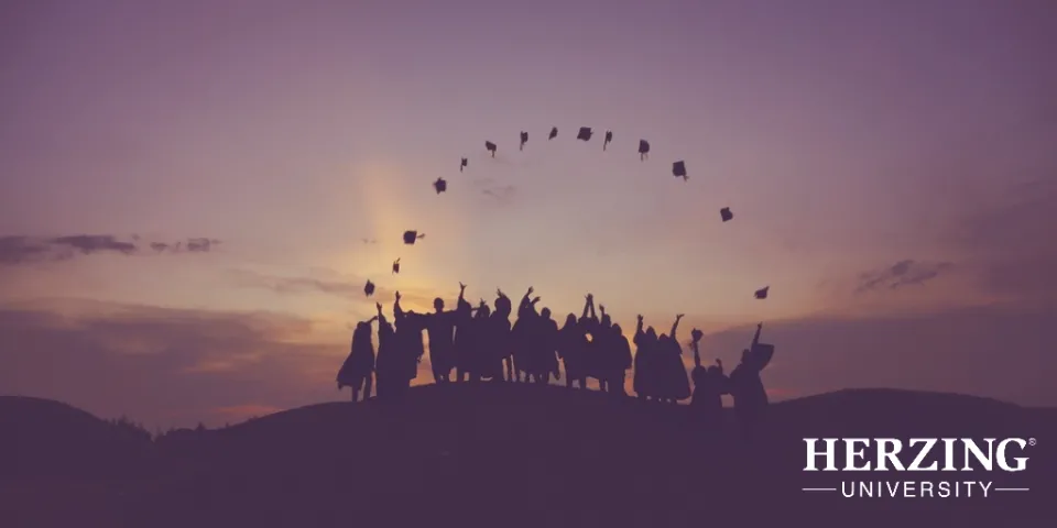College graduates celebrating at sunset