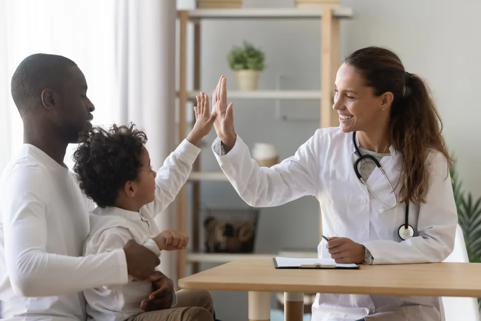 Family Nurse Practitioner High Fiving Pediatric Patient