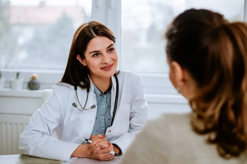 FNP Smiling at Adult Patient in Medical Office