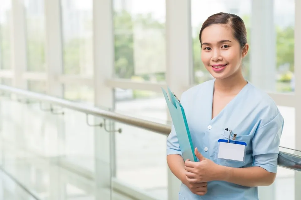 Smiling Medical Assistant Reviewing Patient Chart