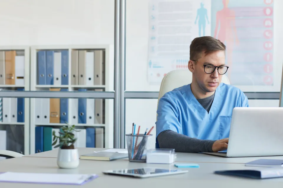 Medical Office Assistant Working on Computer in Clinic