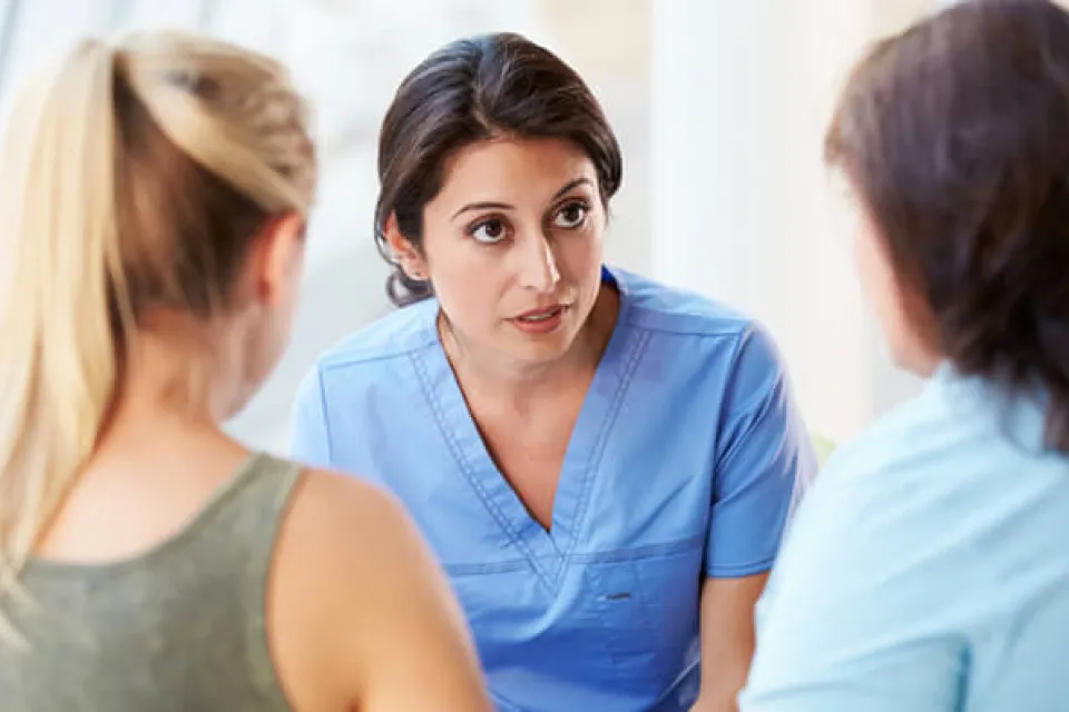 Registered nurse discussing diagnosis with mother and daughter