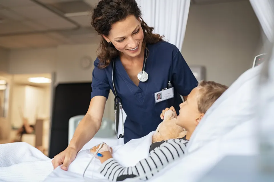 Nurse Smiling with Pediatric Patient in Hospital