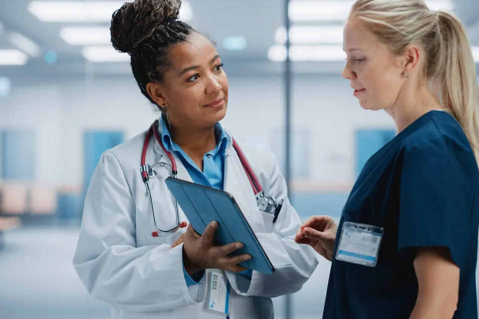 Nurse Practitioner Showing Patient Chart to Registered Nurse