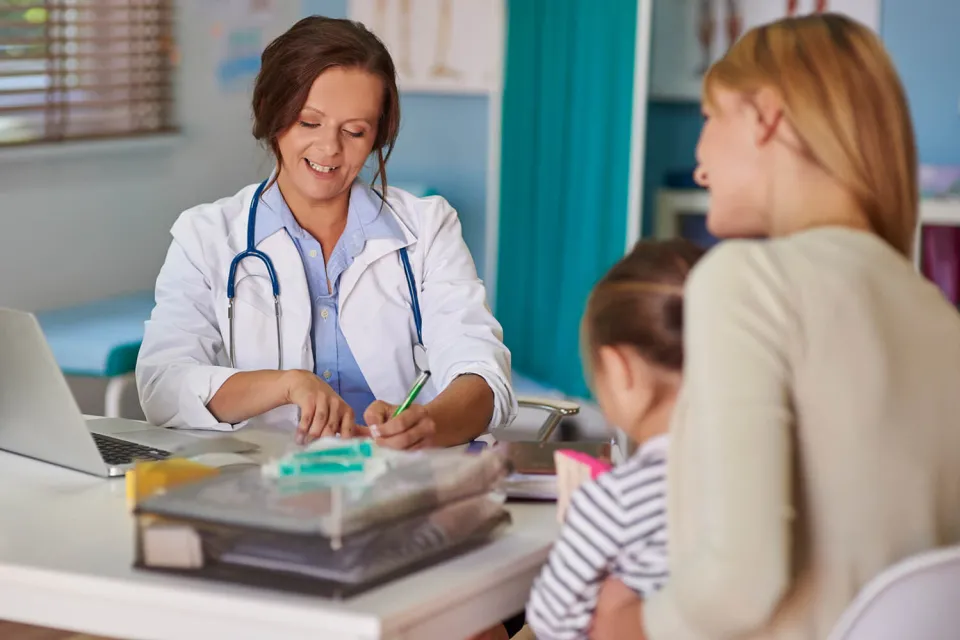 Pediatric Nurse Practitioner Smiling During Exam of Young Patient