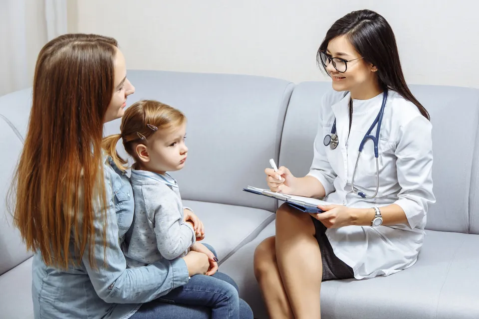 Pediatric Nurse Practitioner Smiling with Patient in Exam