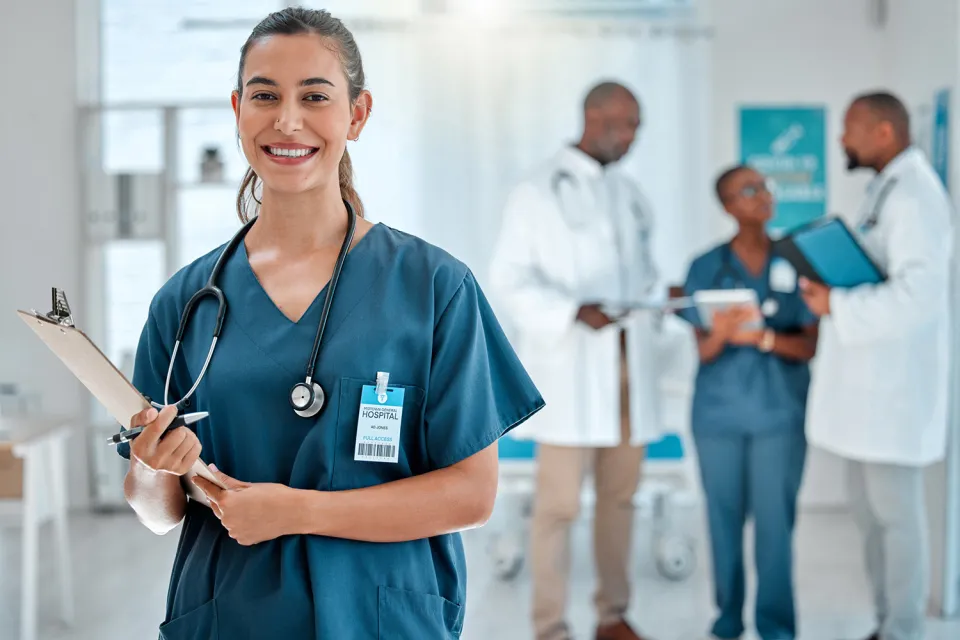 Nurse in Green Scrubs Smiling While Holding Clipboard