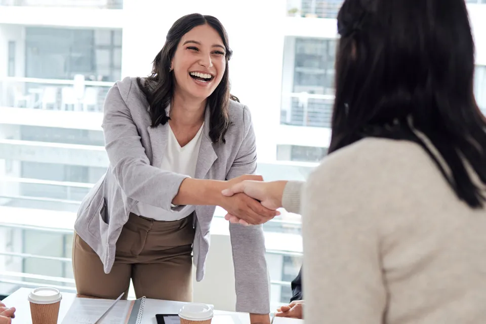 Human Resources Manager Smiling and Shaking Hands with Coworker