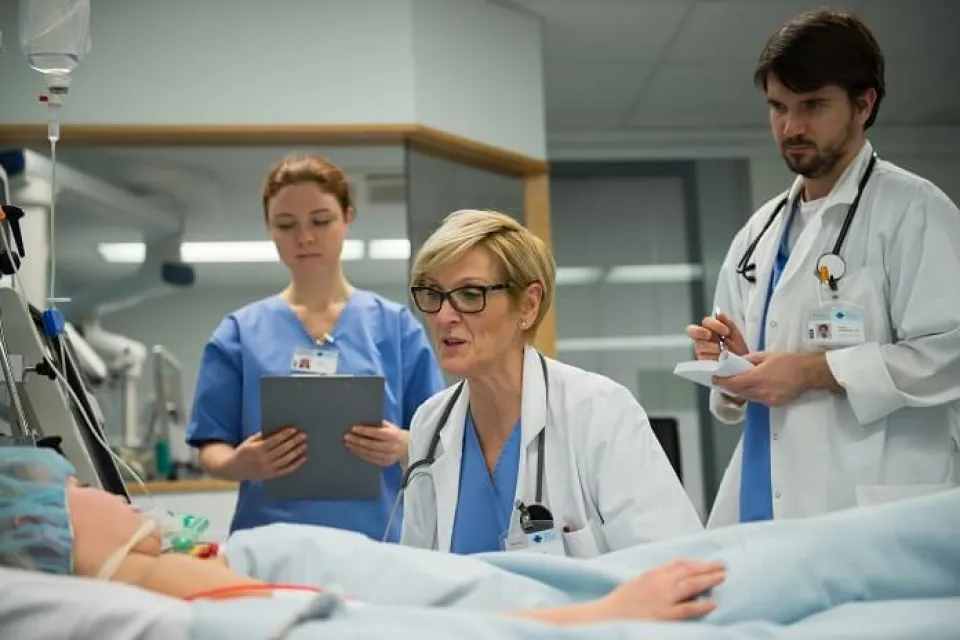 Nurse Practitioner with Medical Team at Patient Bedside