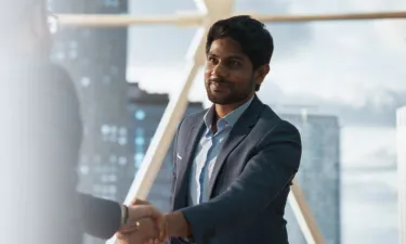 Young MBA business analytics graduate shaking hands with coworker