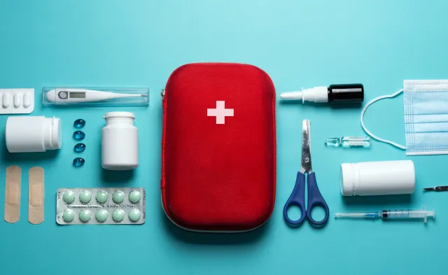 Home first aid kit on a blue background. The elements of the first aid kit